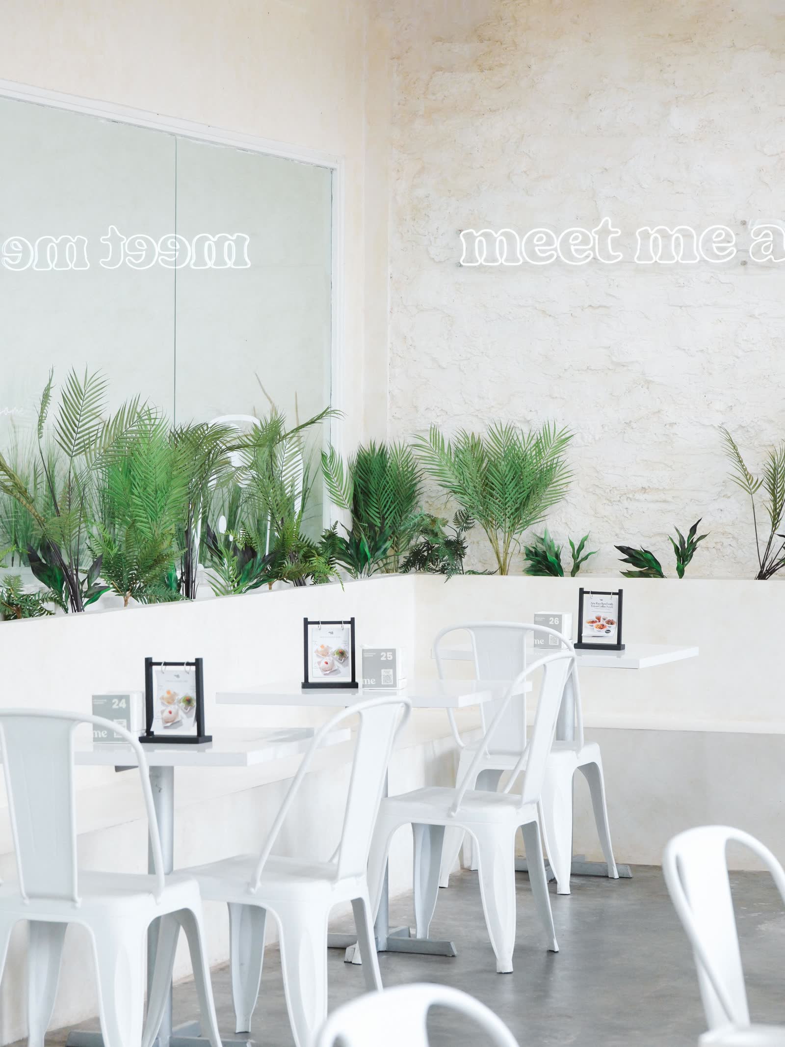 Melt Me interior with neon 'meet me' sign and white chairs