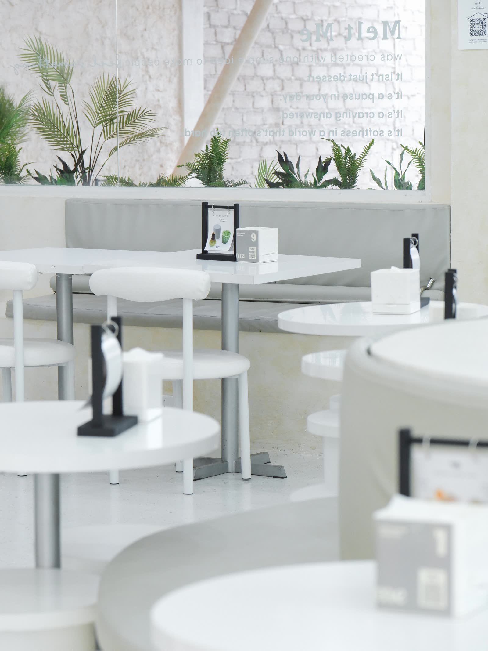Melt Me cafe interior seating area with plants and brand manifesto
