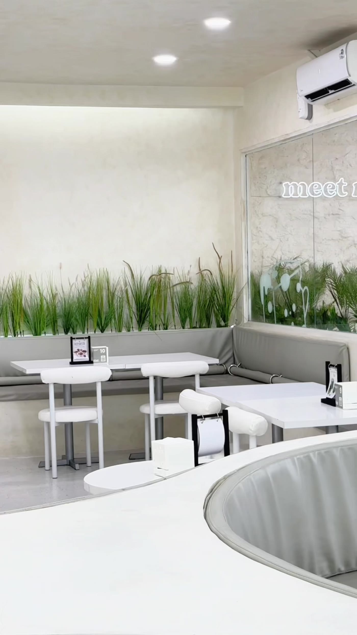 Melt Me cafe interior in Batam with white minimalist design and neon sign